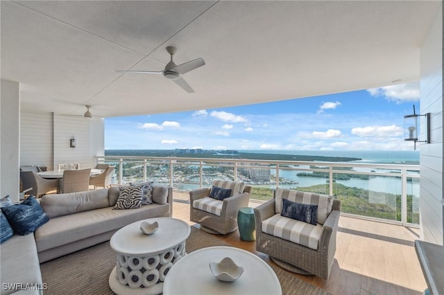 balcony with outdoor dining space, outdoor lounge area, a ceiling fan, and a water view