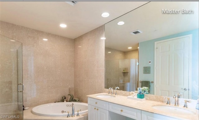 bathroom with a sink, tile walls, and a shower stall