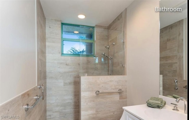 bathroom featuring tiled shower and vanity