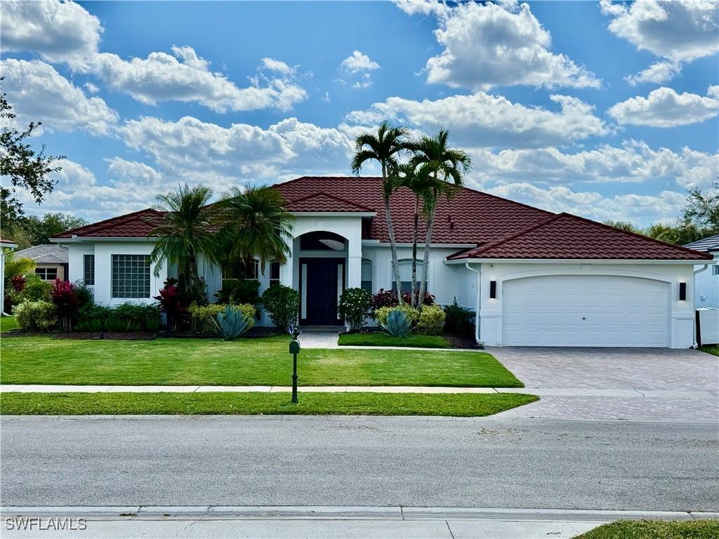 mediterranean / spanish-style house featuring decorative driveway, a tile roof, stucco siding, a front yard, and a garage