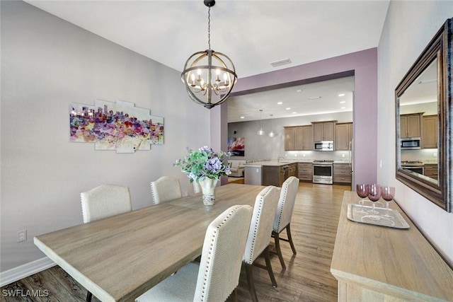 dining area with recessed lighting, visible vents, wood finished floors, and a chandelier