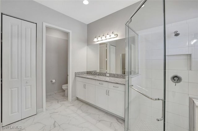 full bathroom featuring vanity, a stall shower, a closet, toilet, and marble finish floor