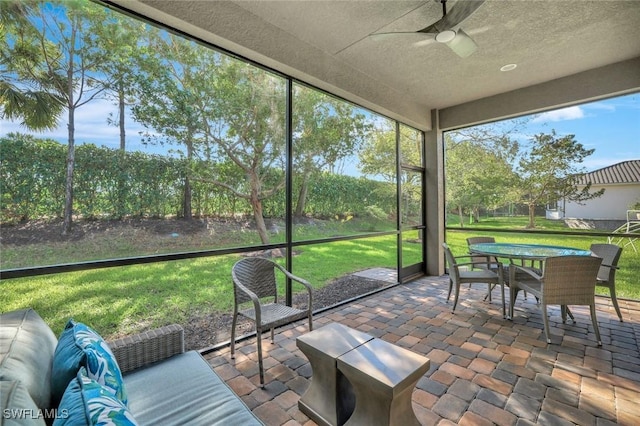 sunroom / solarium featuring a ceiling fan