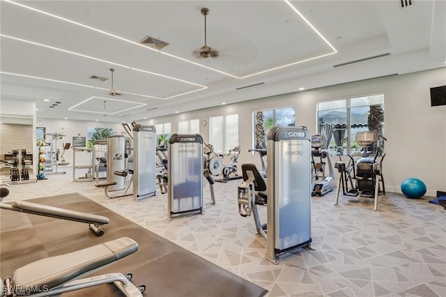 exercise room featuring visible vents, light colored carpet, baseboards, and a tray ceiling