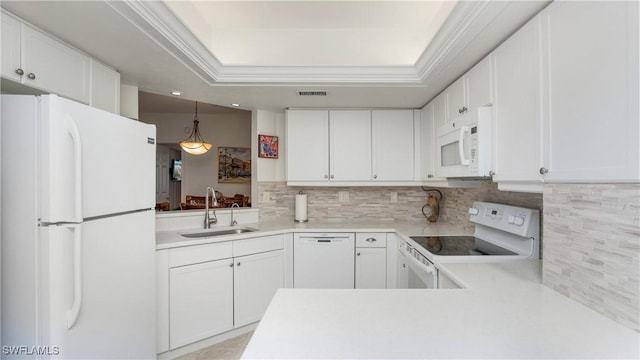 kitchen with white appliances, a sink, visible vents, decorative backsplash, and a raised ceiling