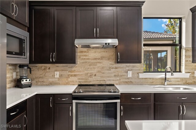 12108 Sussex St, Fort Myers, FL 33913 - kitchen with a sink, stainless steel appliances, light countertops, backsplash, and under cabinet range hood