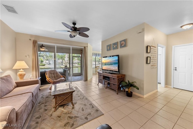 living room with light tile patterned floors, visible vents, baseboards, and ceiling fan