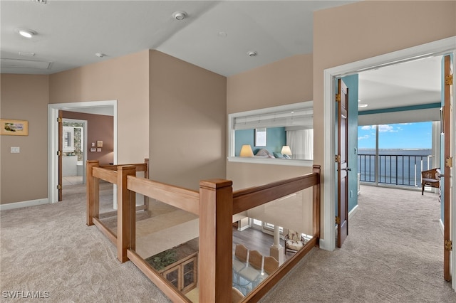 corridor with carpet, an upstairs landing, and baseboards