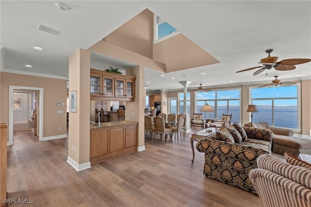 living room featuring light wood-style flooring, ornamental molding, baseboards, and recessed lighting