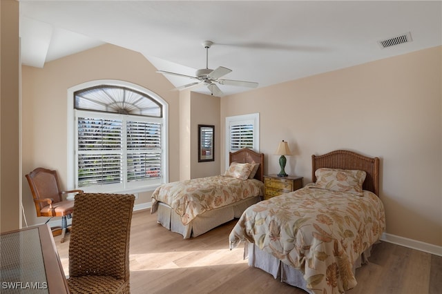 bedroom featuring baseboards, ceiling fan, visible vents, and light wood-style floors