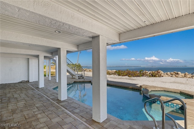 outdoor pool featuring a water view, stairway, and a patio