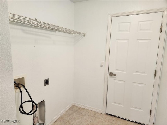 clothes washing area featuring laundry area, baseboards, hookup for a washing machine, electric dryer hookup, and light tile patterned flooring