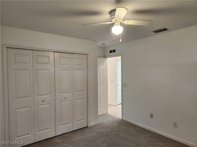 unfurnished bedroom with carpet floors, a closet, visible vents, and baseboards