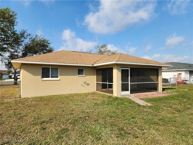 back of house with a yard, fence, a sunroom, and stucco siding