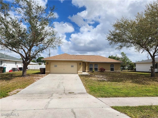 single story home featuring an attached garage, central air condition unit, concrete driveway, stucco siding, and a front yard