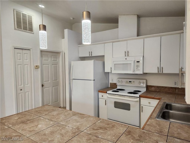 kitchen with white appliances, visible vents, tile patterned floors, white cabinetry, and a sink