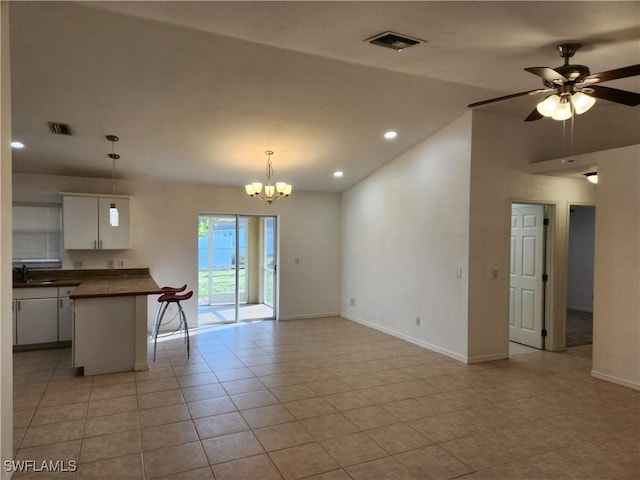 interior space featuring ceiling fan with notable chandelier, a sink, visible vents, and baseboards