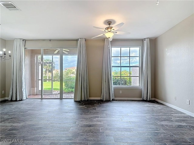 empty room with visible vents, ceiling fan, baseboards, and wood finished floors