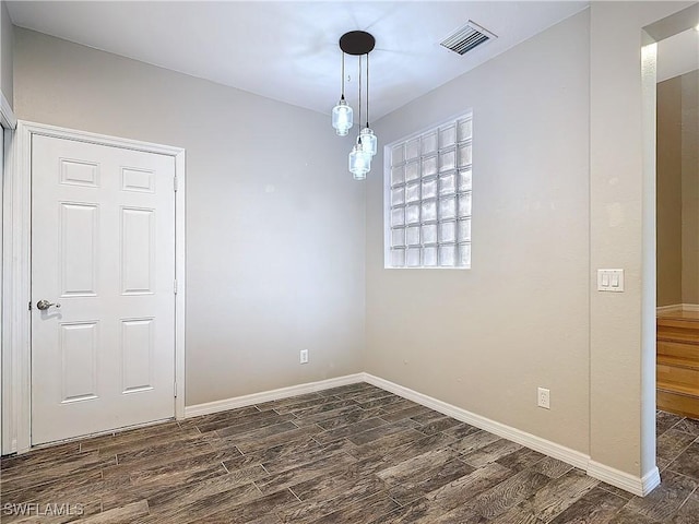 unfurnished room with baseboards, visible vents, and dark wood-style flooring