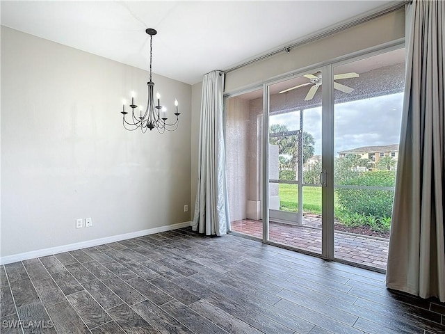 empty room featuring baseboards, dark wood-style flooring, and ceiling fan with notable chandelier