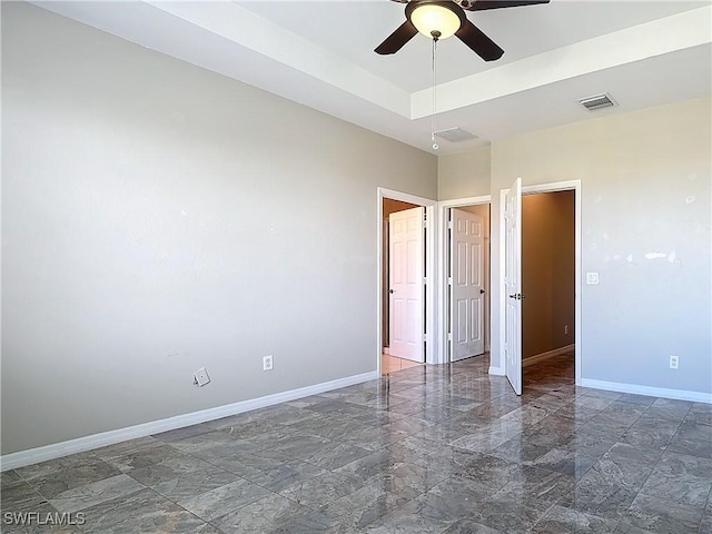 unfurnished bedroom with a ceiling fan, visible vents, baseboards, marble finish floor, and a raised ceiling