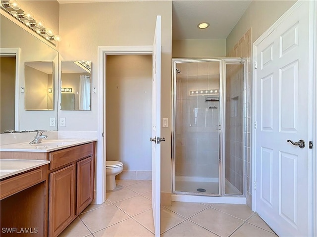 bathroom with vanity, tile patterned flooring, toilet, and a shower stall