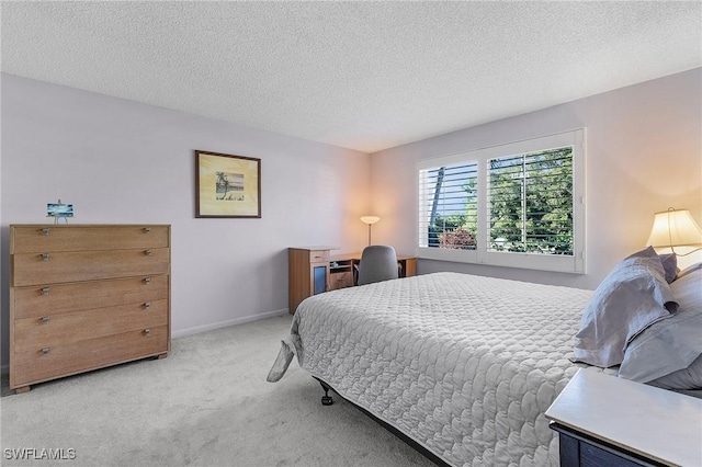 bedroom with baseboards, light carpet, and a textured ceiling