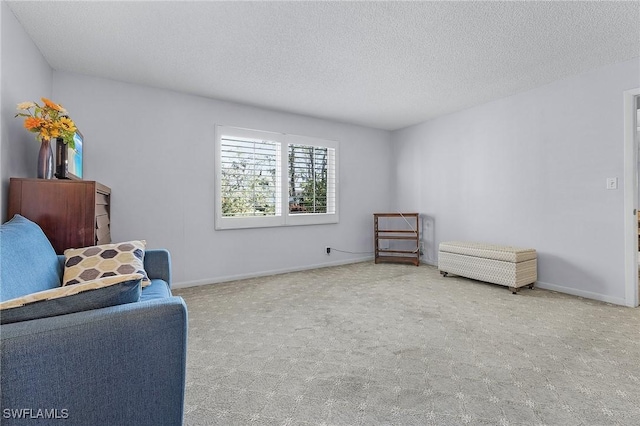 living area with carpet flooring, baseboards, and a textured ceiling