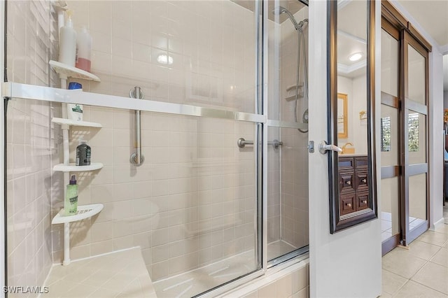 full bath with tile patterned floors, a shower stall, and baseboards