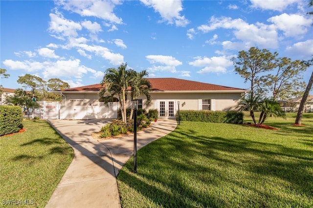 view of front of house featuring french doors, a front lawn, and stucco siding