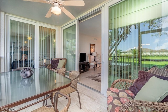 sunroom featuring a ceiling fan