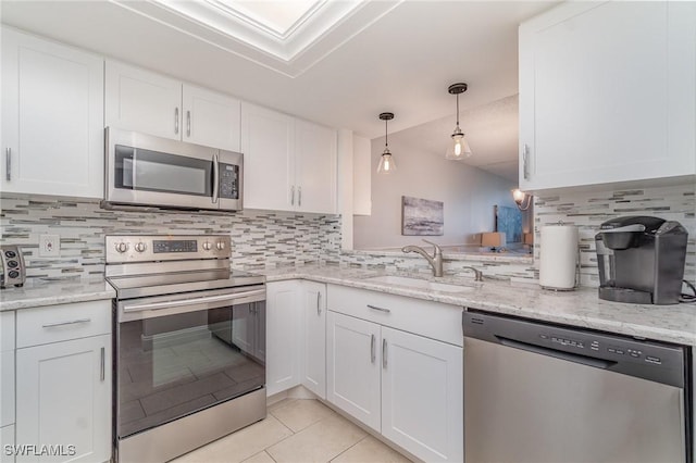 kitchen featuring light tile patterned floors, decorative backsplash, appliances with stainless steel finishes, white cabinetry, and a sink