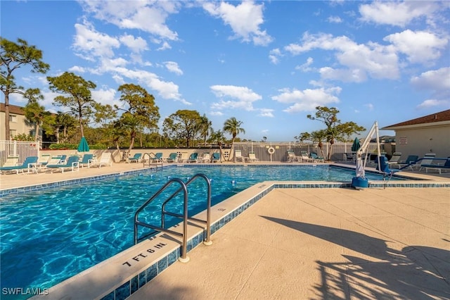 community pool featuring fence and a patio