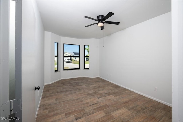 spare room featuring ceiling fan, wood finished floors, and baseboards