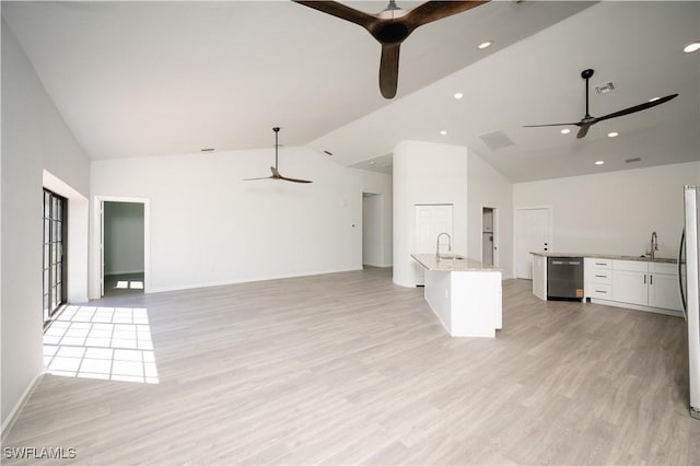 kitchen with ceiling fan, open floor plan, and a sink