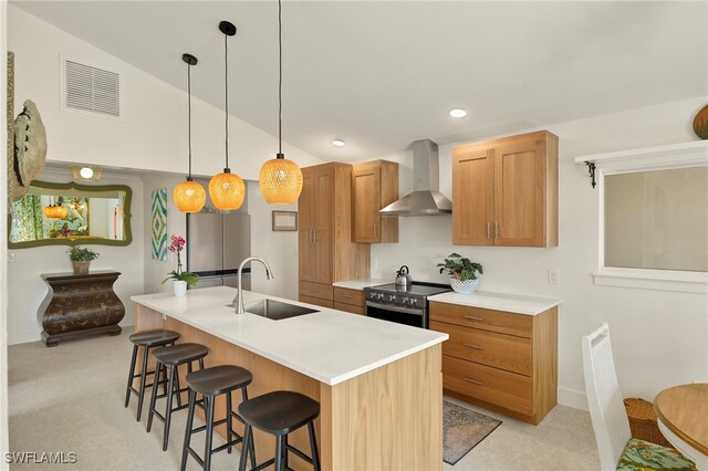 kitchen featuring visible vents, stainless steel electric range oven, wall chimney exhaust hood, a breakfast bar, and a sink