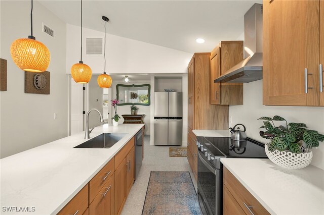 kitchen featuring visible vents, wall chimney exhaust hood, stainless steel appliances, light countertops, and a sink