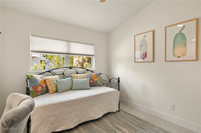 carpeted bedroom with vaulted ceiling and baseboards