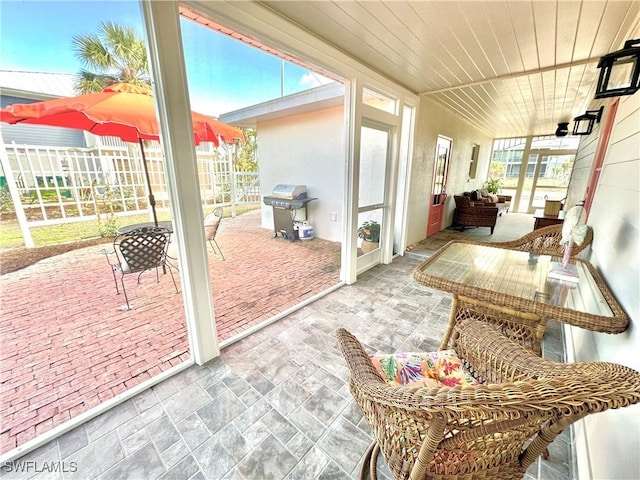 sunroom featuring wooden ceiling and plenty of natural light