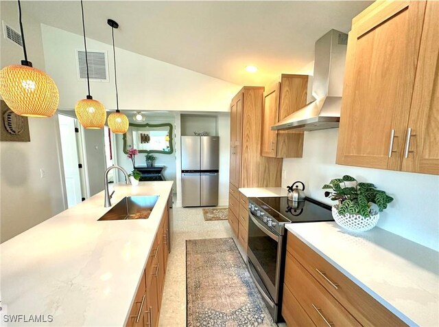 kitchen with visible vents, stainless steel appliances, light countertops, wall chimney range hood, and a sink