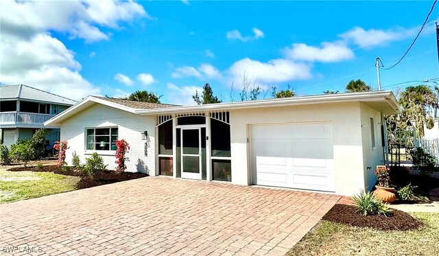 single story home with a garage, decorative driveway, and stucco siding