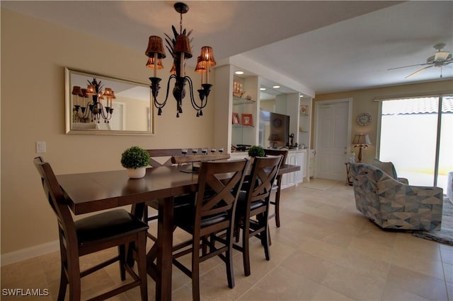 dining room with baseboards and ceiling fan with notable chandelier