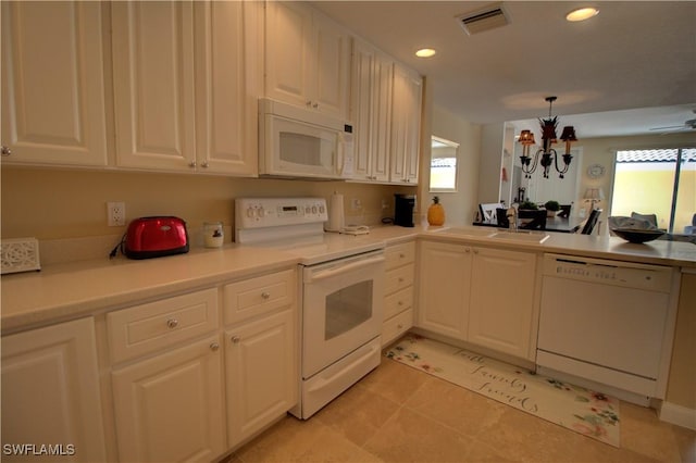 kitchen with white appliances, visible vents, white cabinets, light countertops, and a sink