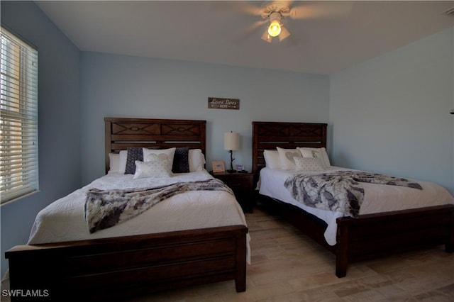 bedroom featuring light wood-style floors, visible vents, and a ceiling fan