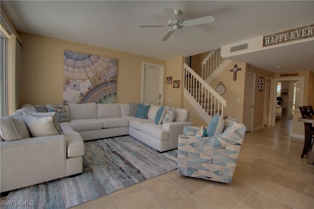 tiled living room with ceiling fan, stairway, visible vents, and baseboards