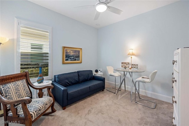 living area with baseboards, carpet floors, and ceiling fan