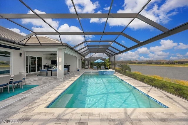 view of swimming pool featuring a water view, a pool with connected hot tub, ceiling fan, a patio, and a lanai