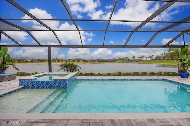 view of swimming pool featuring glass enclosure, a water view, and a pool with connected hot tub