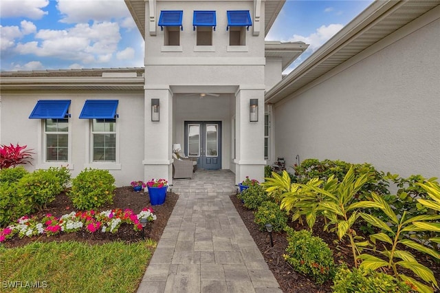 property entrance featuring stucco siding and french doors