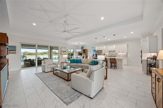 living room featuring baseboards, a tray ceiling, recessed lighting, marble finish floor, and a ceiling fan